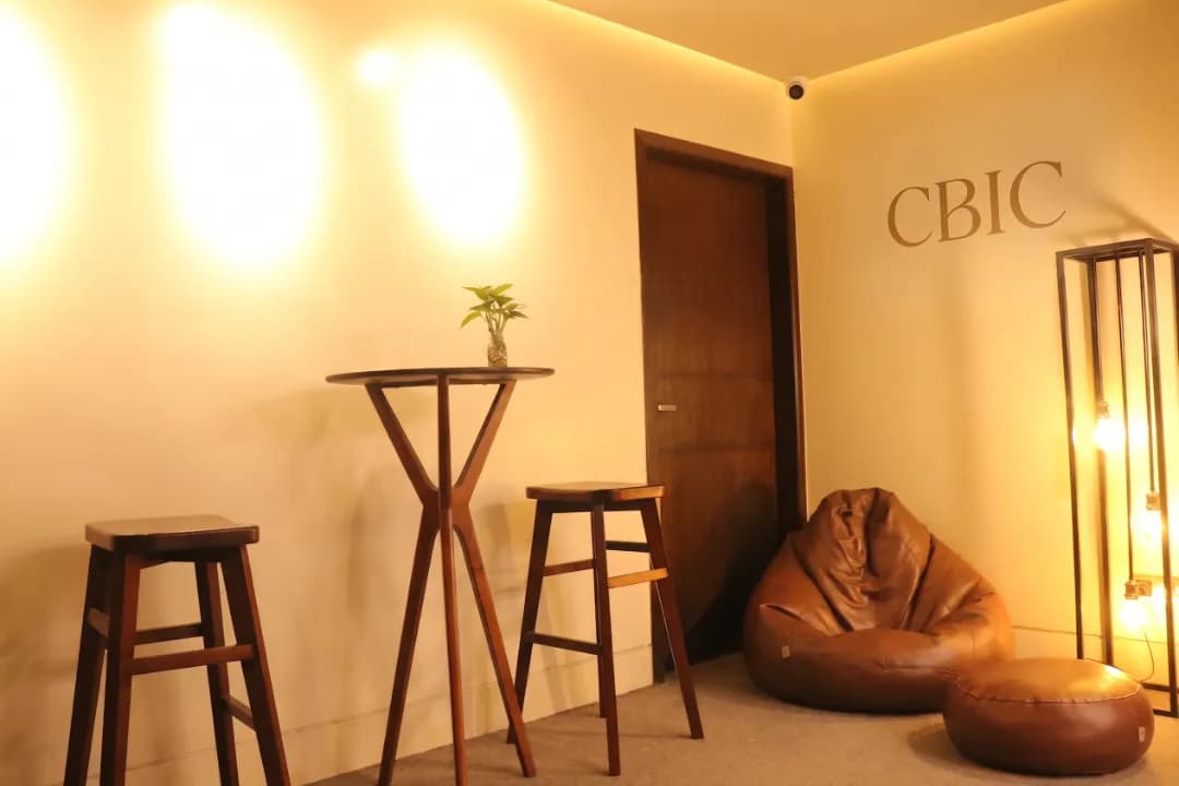 The CBIC boardroom in Dhaka, the branded wall behind an empty conference table